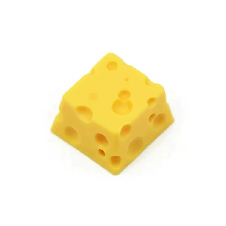 Yellow resin mechanical keyboard keycap sculpted like a wedge of Swiss cheese.