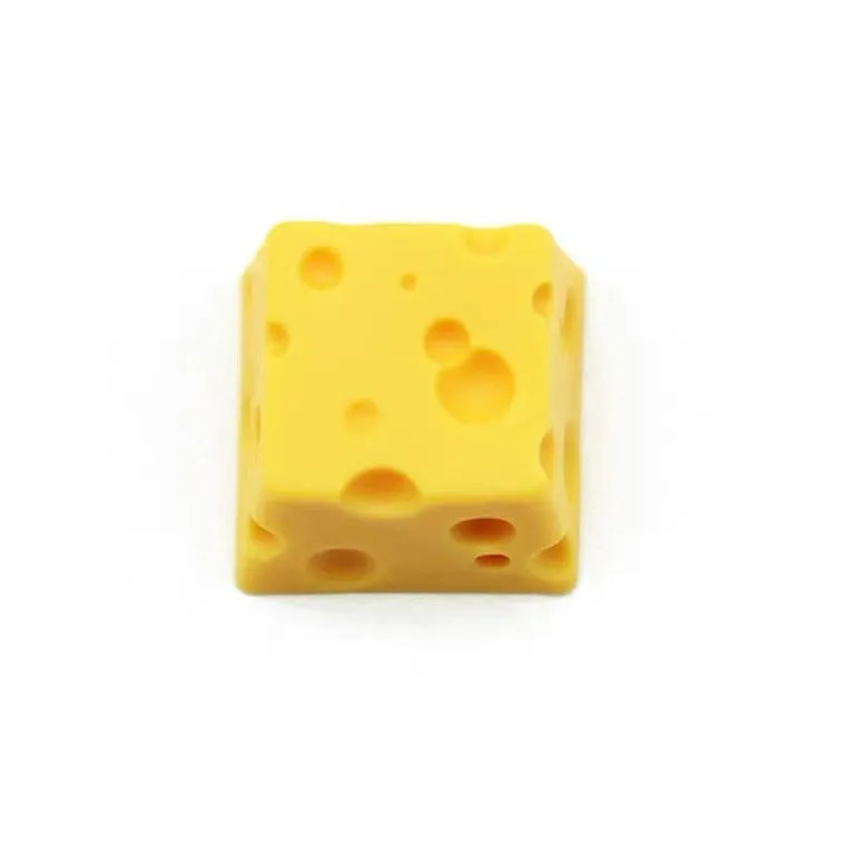 Yellow resin mechanical keyboard keycap sculpted like a wedge of Swiss cheese.