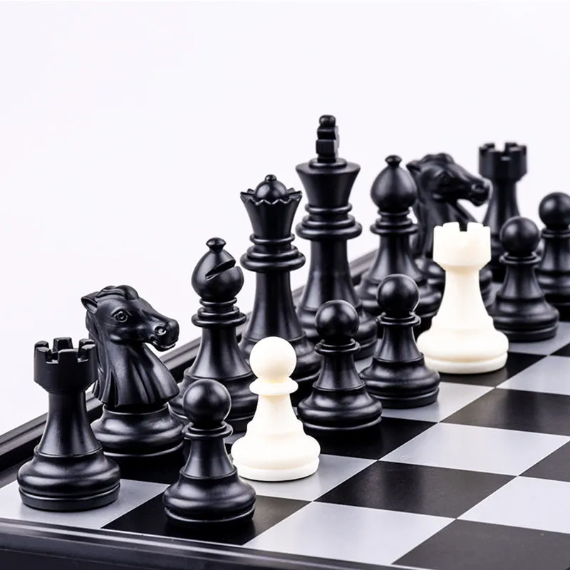 Three-in-one magnetic chess checkers backgammon board game with plastic board and ABS pieces on a table