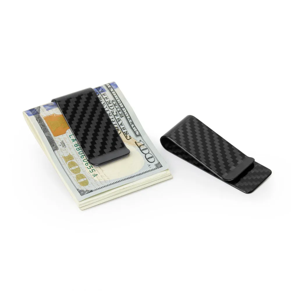 Glossy black genuine carbon fiber money clip on a flat surface, showing striped pattern and slim profile