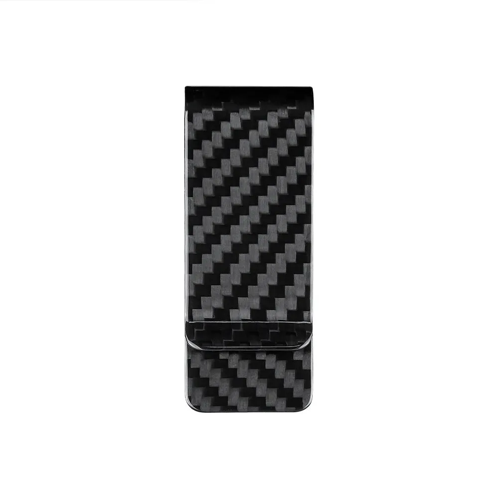 Glossy black genuine carbon fiber money clip on a flat surface, showing striped pattern and slim profile