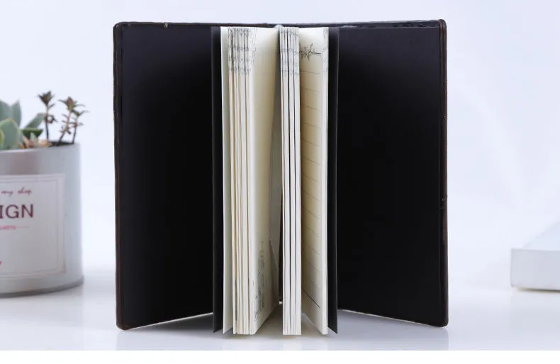 Hardcover PU leather notebook with embossed retro cover and brushed bronze details, open at 180 degrees showing beige pages