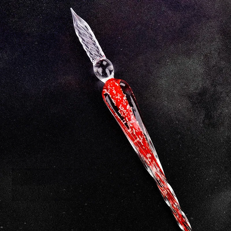 Crystal glass dip pen with transparent body and coloured ink, on a white background