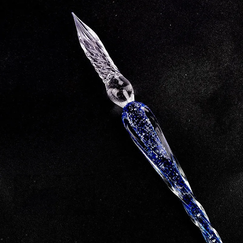 Crystal glass dip pen with transparent body and coloured ink, on a white background