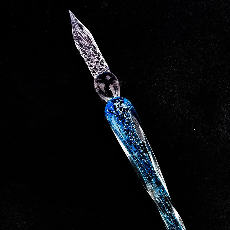 Crystal glass dip pen with transparent body and coloured ink, on a white background