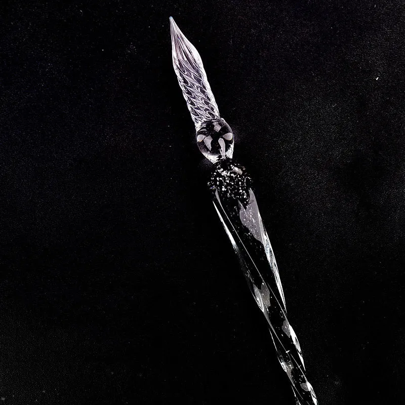 Crystal glass dip pen with transparent body and coloured ink, on a white background