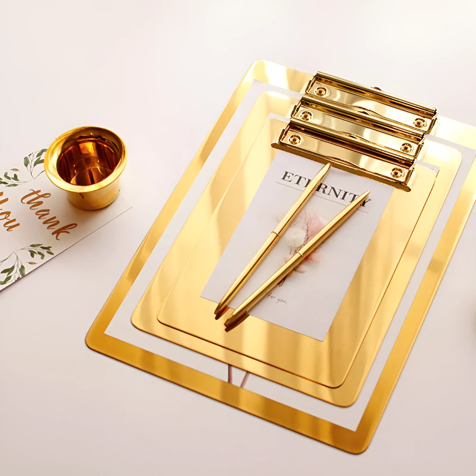 Stainless steel golden folder board in three sizes small, medium, and large on a white background