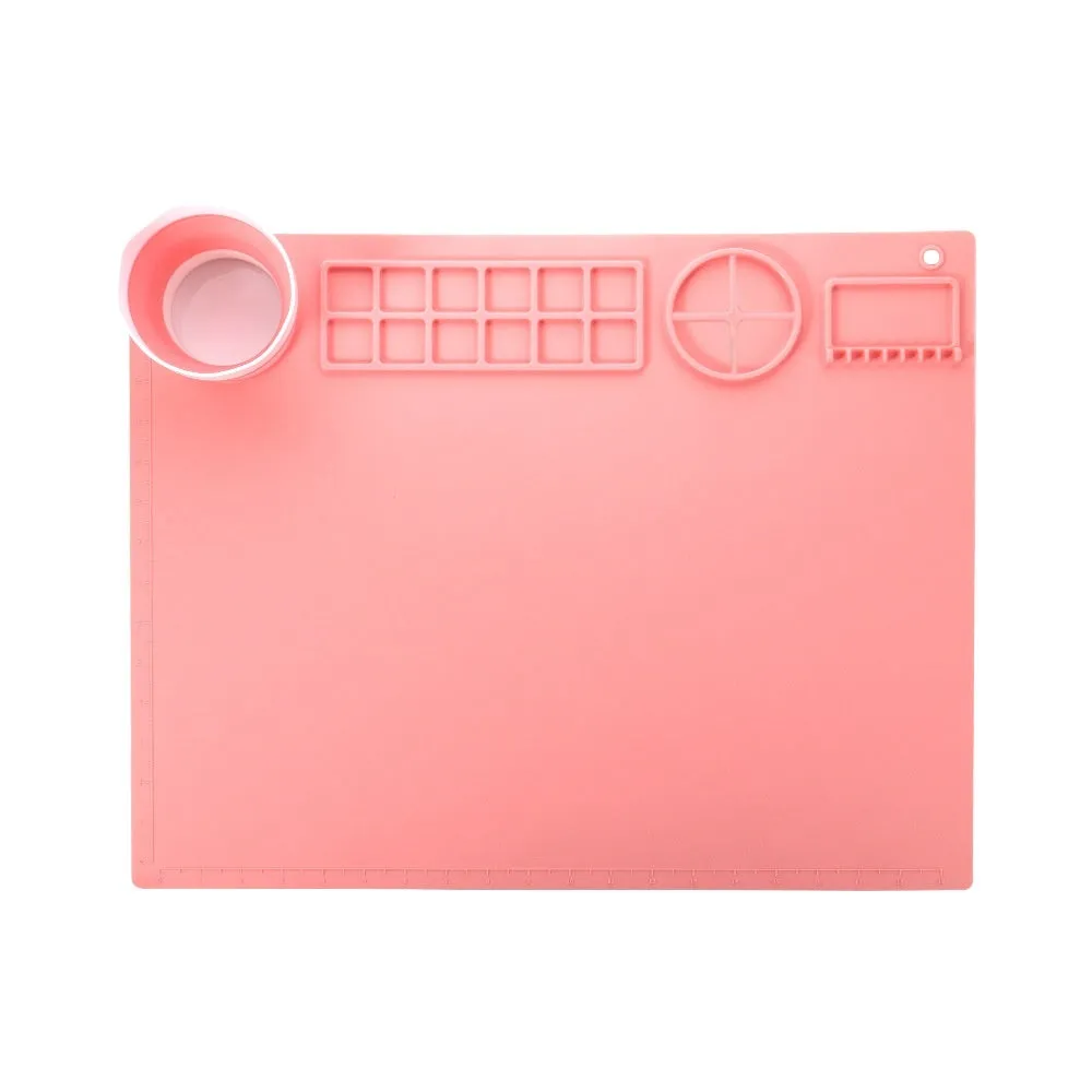 Light blue silicone painting mat measuring 50 by 40 centimetres on a wooden table.