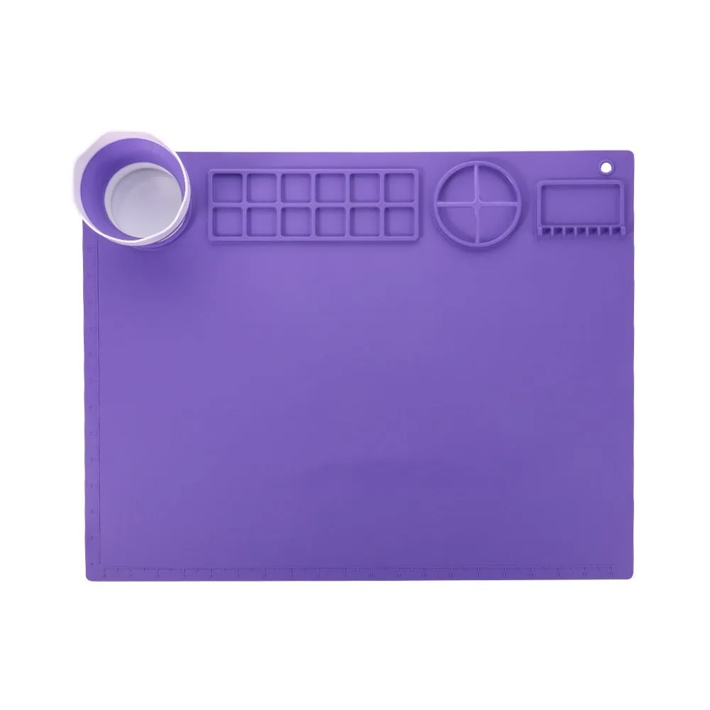 Light blue silicone painting mat measuring 50 by 40 centimetres on a wooden table.