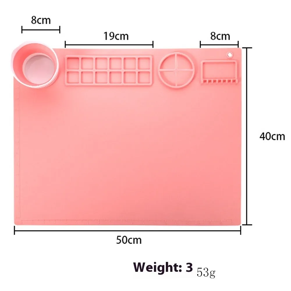 Light blue silicone painting mat measuring 50 by 40 centimetres on a wooden table.