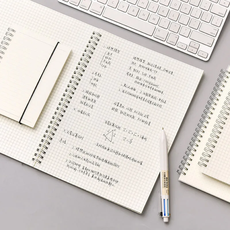 B5 coil grid notebook with Pp cover, open showing lined pages on a desk