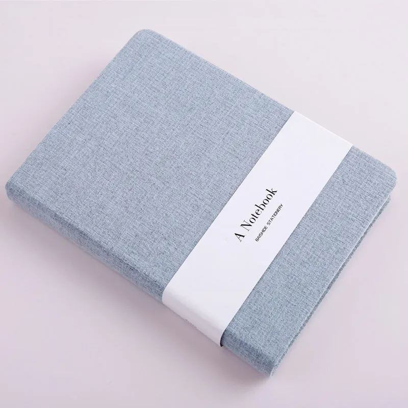 Cloth-covered wire-bound notebook with 132 pages, small size 10.5x14.5cm, showing blank and ruled pages in blue