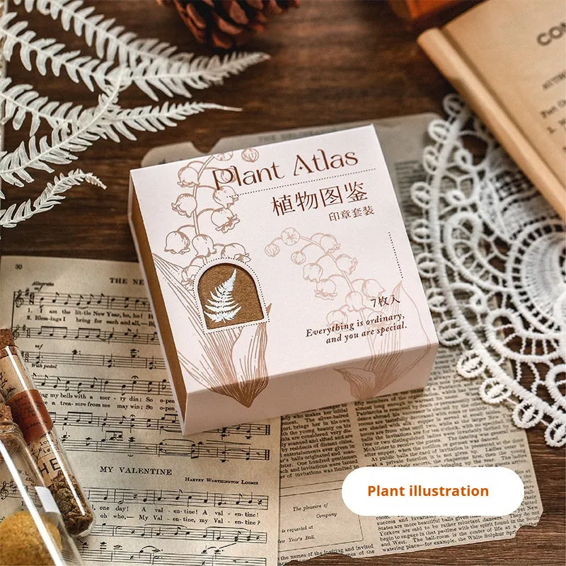 Mr Paper Seal Suit wooden stamp set showing seven stamps in either stars and moon or botanical designs on a craft table.