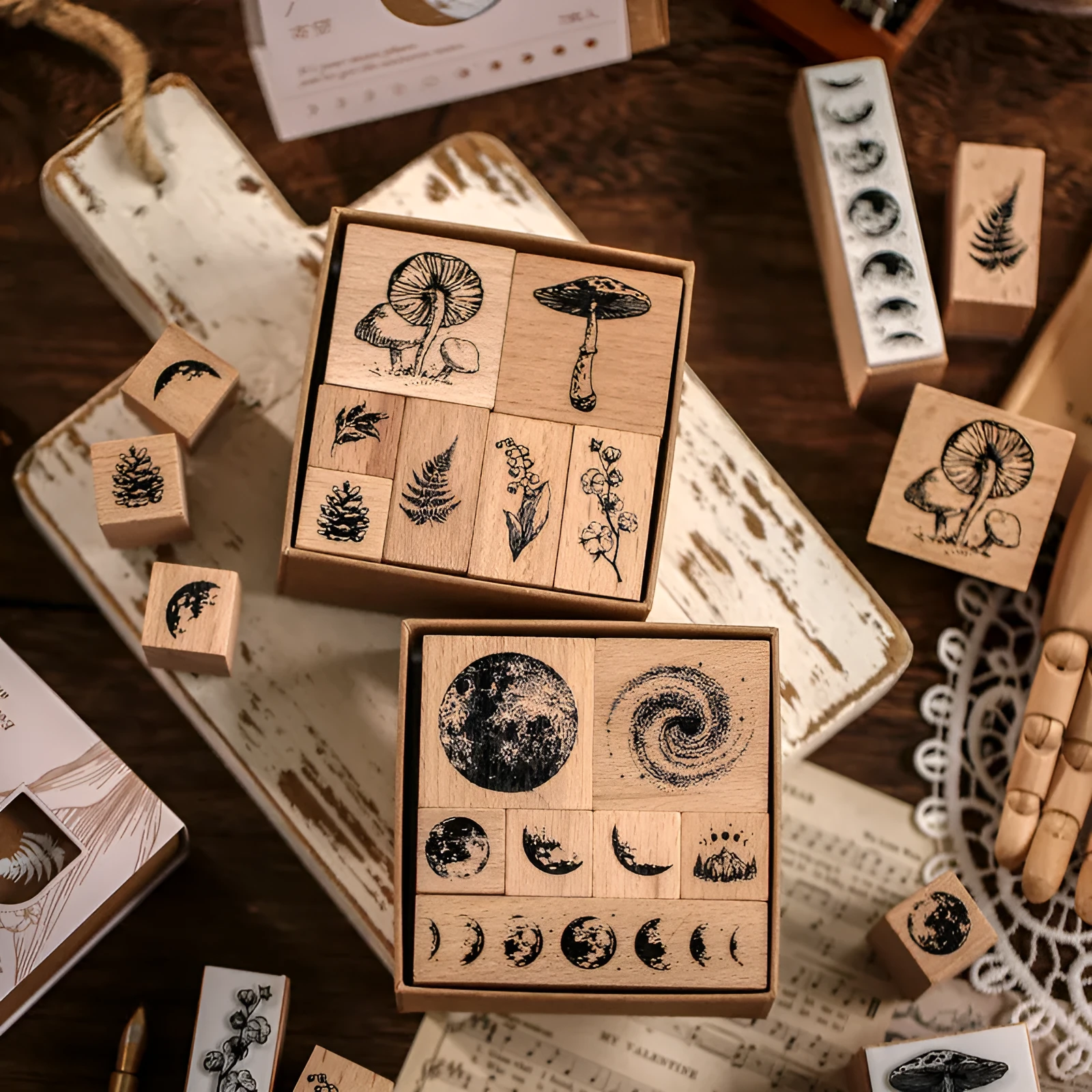 Mr Paper Seal Suit wooden stamp set showing seven stamps in either stars and moon or botanical designs on a craft table.