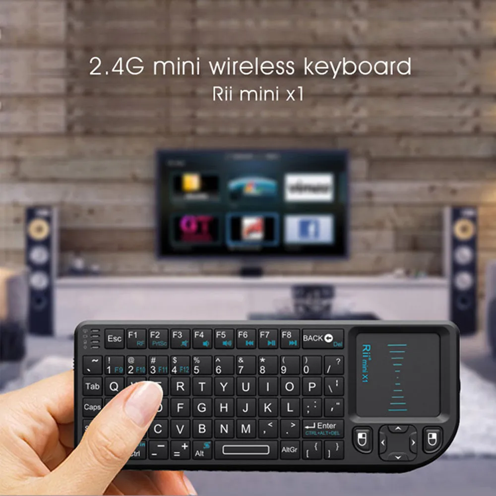 Black wireless mini keyboard with built-in trackpad and 2.4GHz receiver on a desk