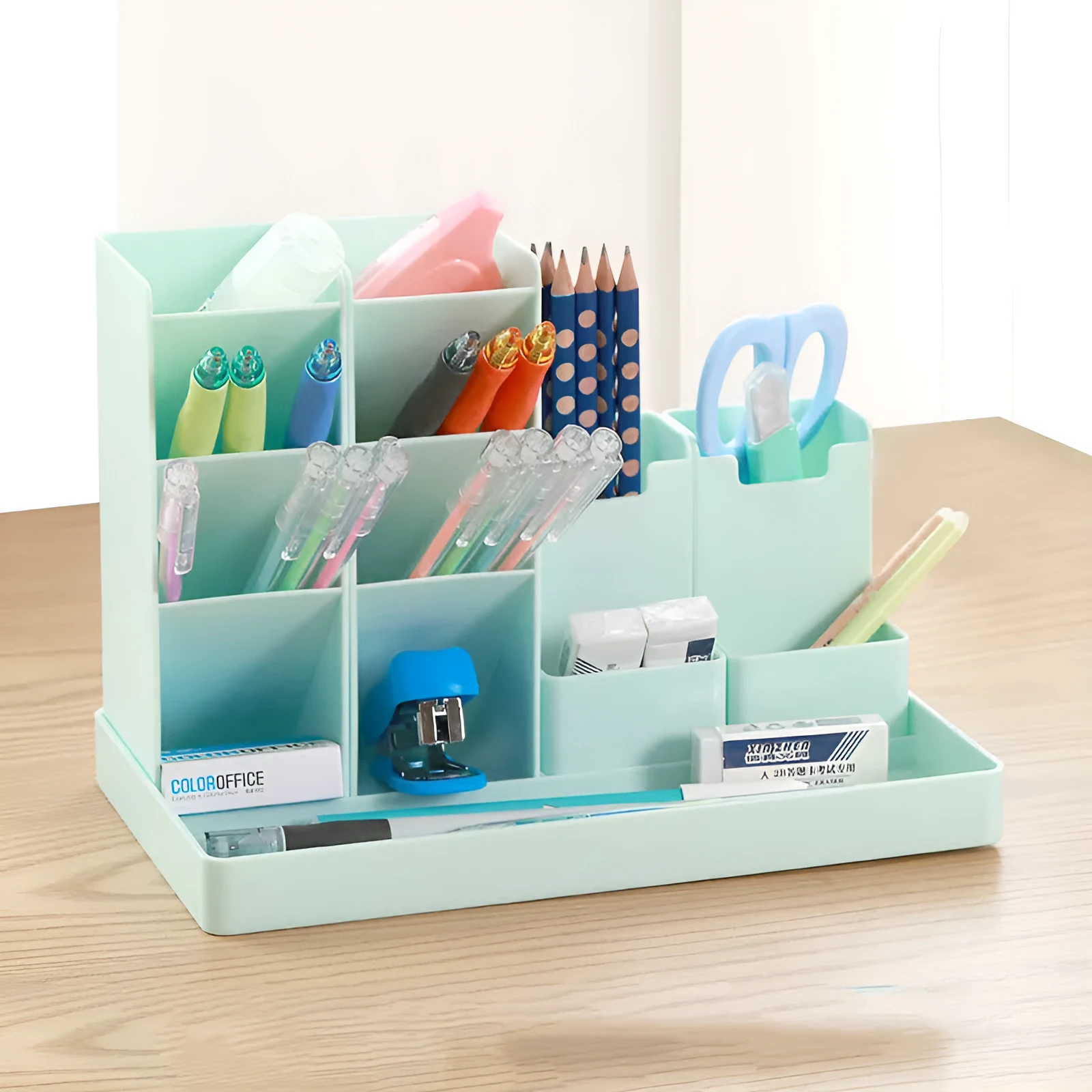 Combination pen holder in turquoise green with multiple storage grids for pens on a desk