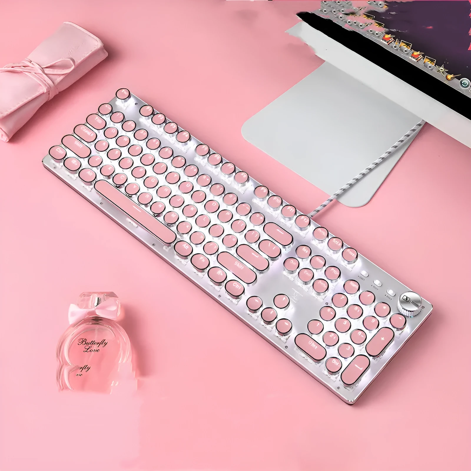 Silver and pink mechanical keyboard with green switches and white backlighting on a desk.