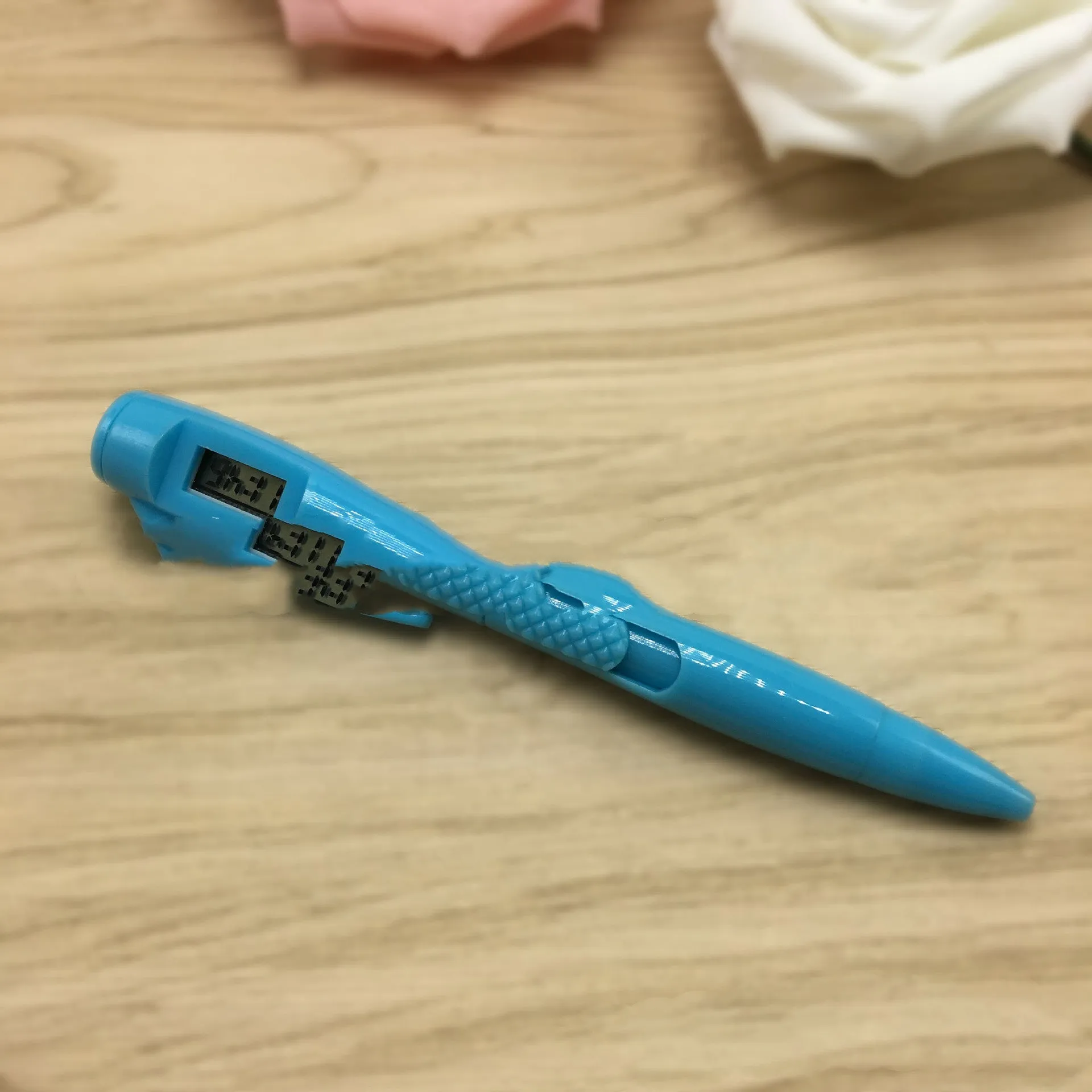 Electronic watch test ballpoint pen with plastic shell in a colour option, on a plain background