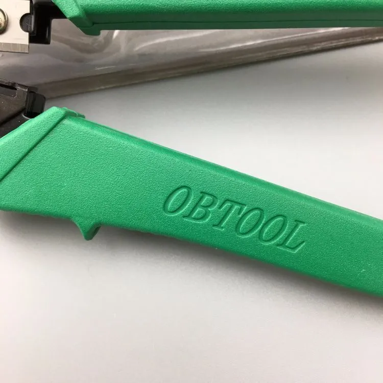 Green dual-purpose crystal head net pliers with tool steel jaws and plastic handle on plain background