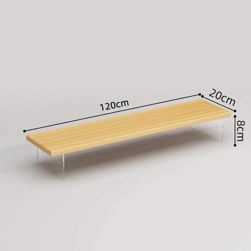 Black computer riser with acrylic legs on desk under monitor