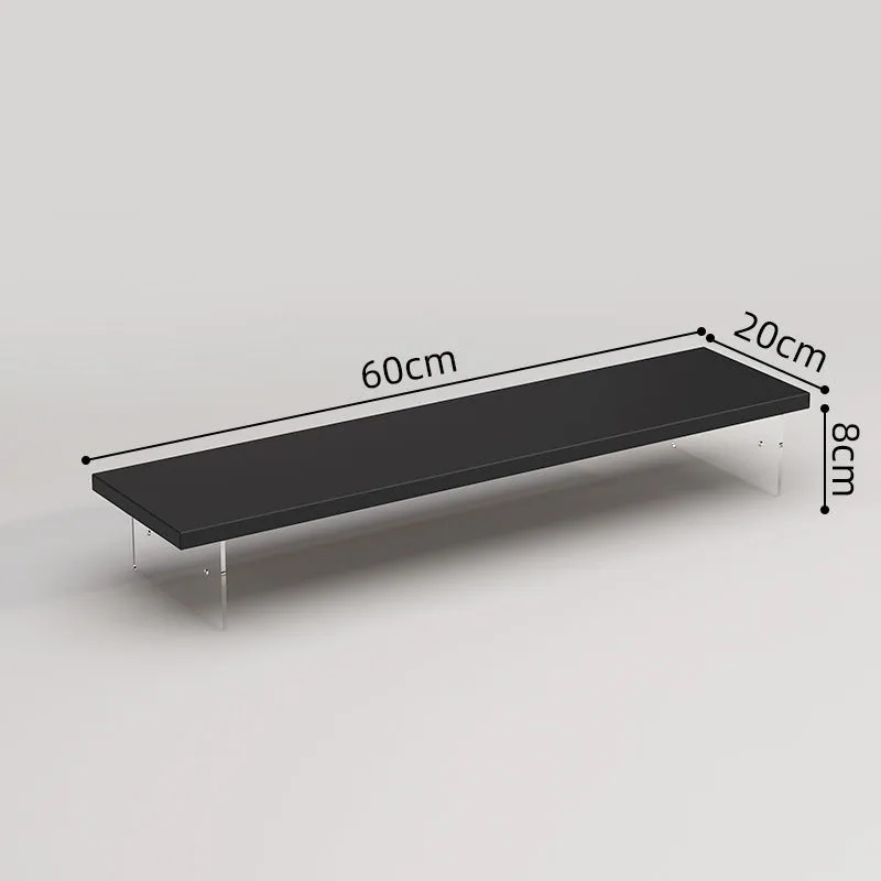 Black computer riser with acrylic legs on desk under monitor