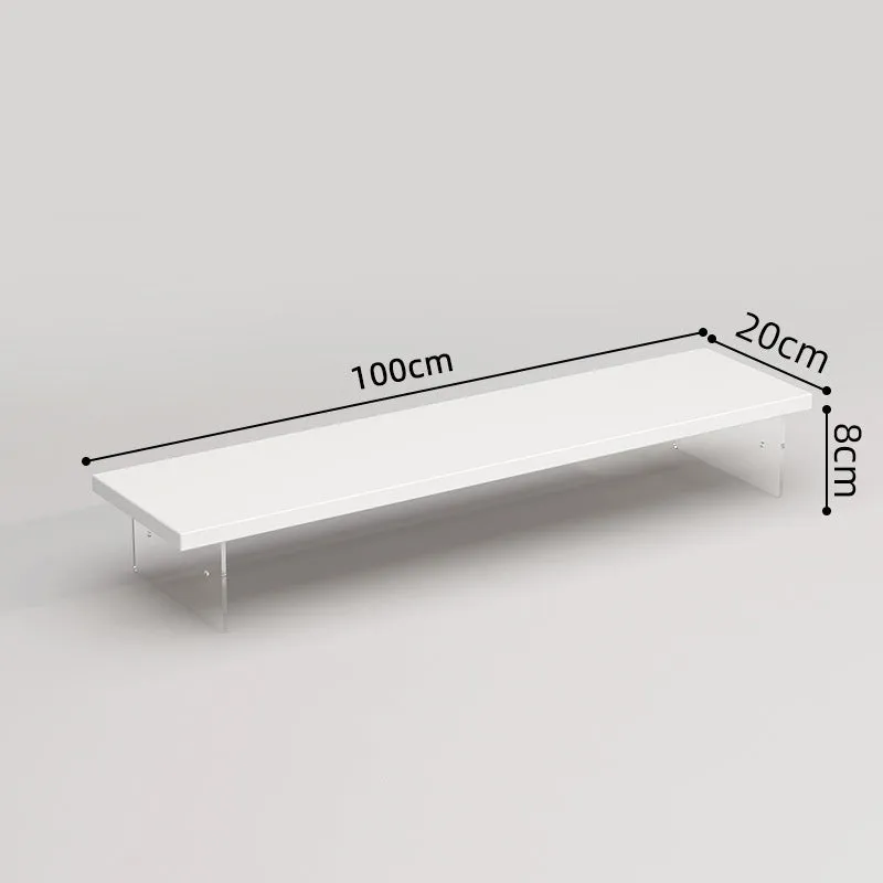 Black computer riser with acrylic legs on desk under monitor