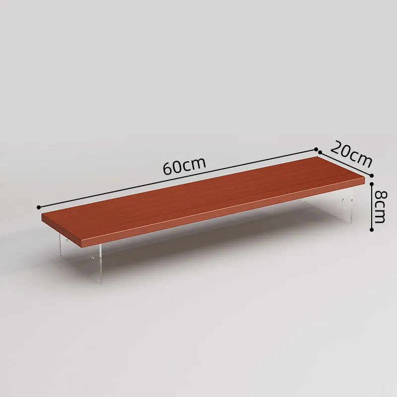 Black computer riser with acrylic legs on desk under monitor