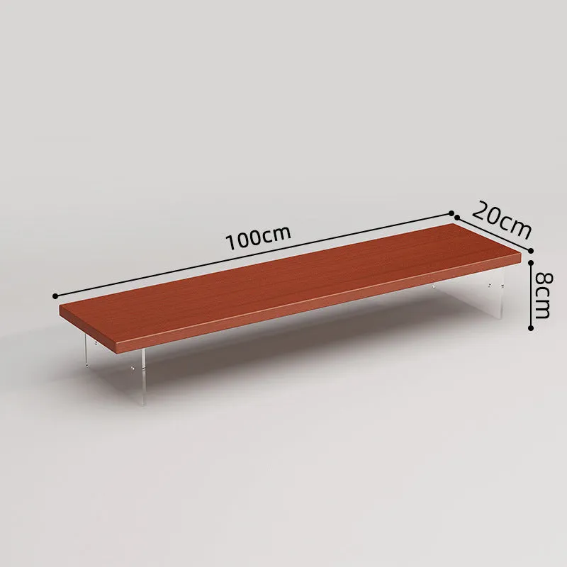 Black computer riser with acrylic legs on desk under monitor