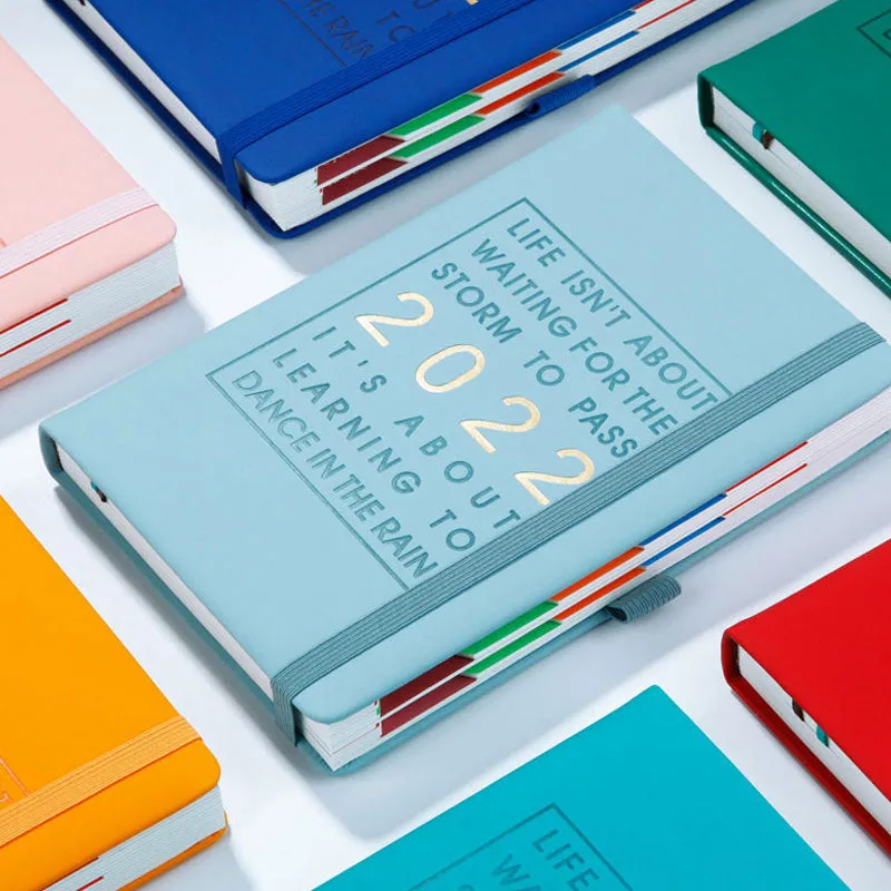 A5 imitation leather notebook with French fold binding open flat on a desk, seven colour options