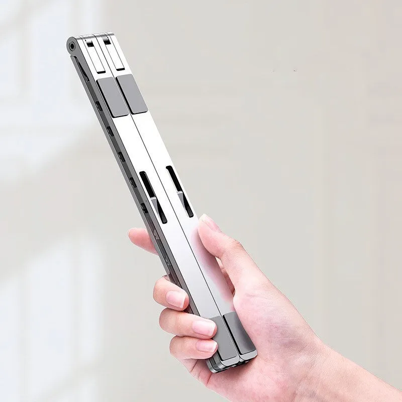 Folding flat aluminium alloy laptop stand in grey, 255x35x13mm, angled to show silicone pads and hinge mechanism