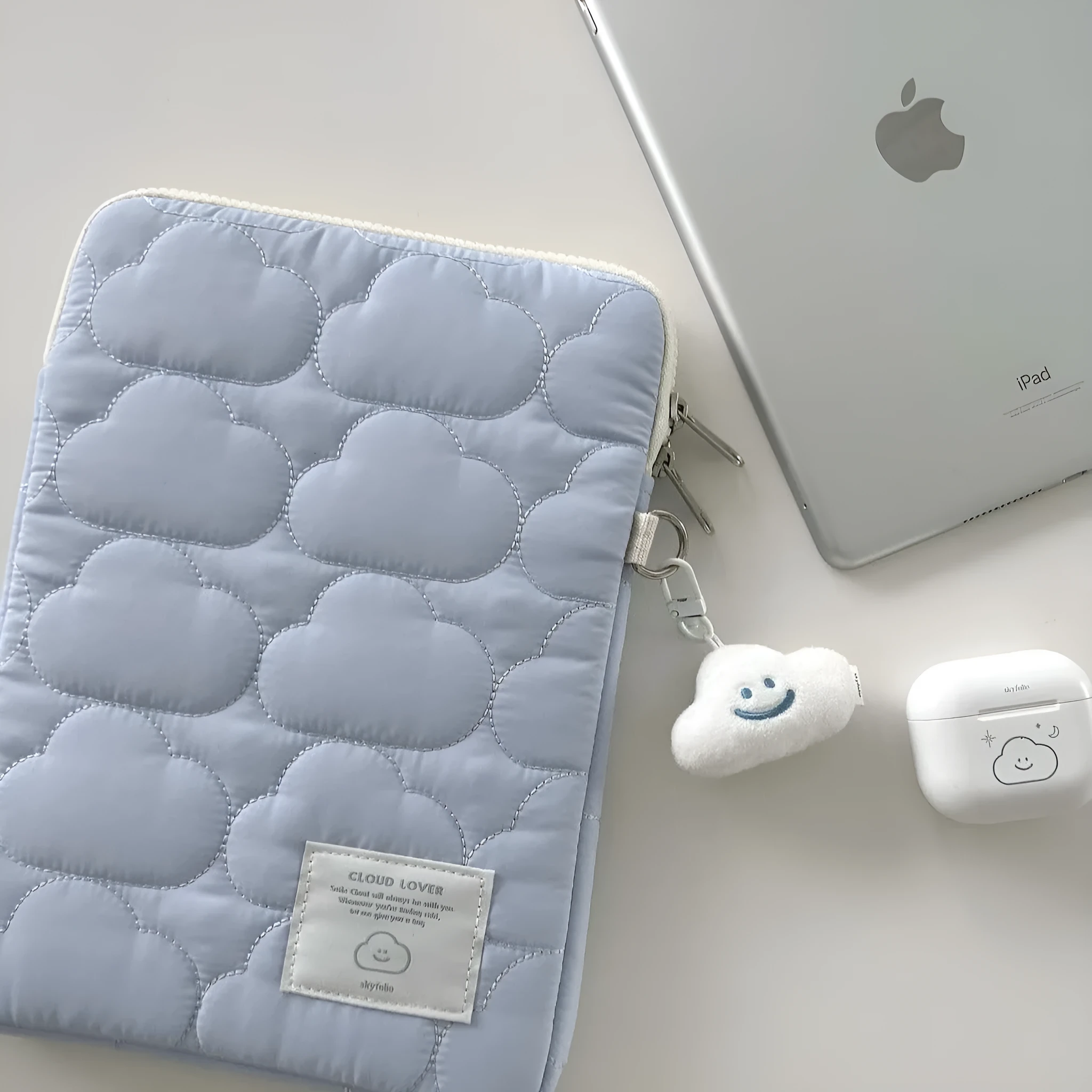 White cotton notebook storage bag with blue cloud embroidery on a table
