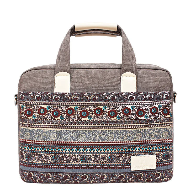 Ethnic style canvas laptop bag in lake blue with zippered front pocket on a table