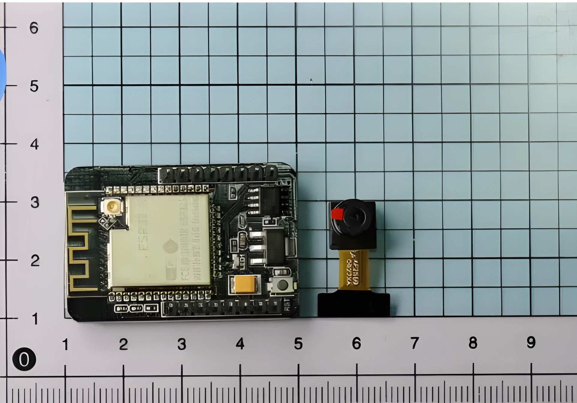 ESP32-CAM development board with OV2640 camera and WiFi Bluetooth module on a neutral background
