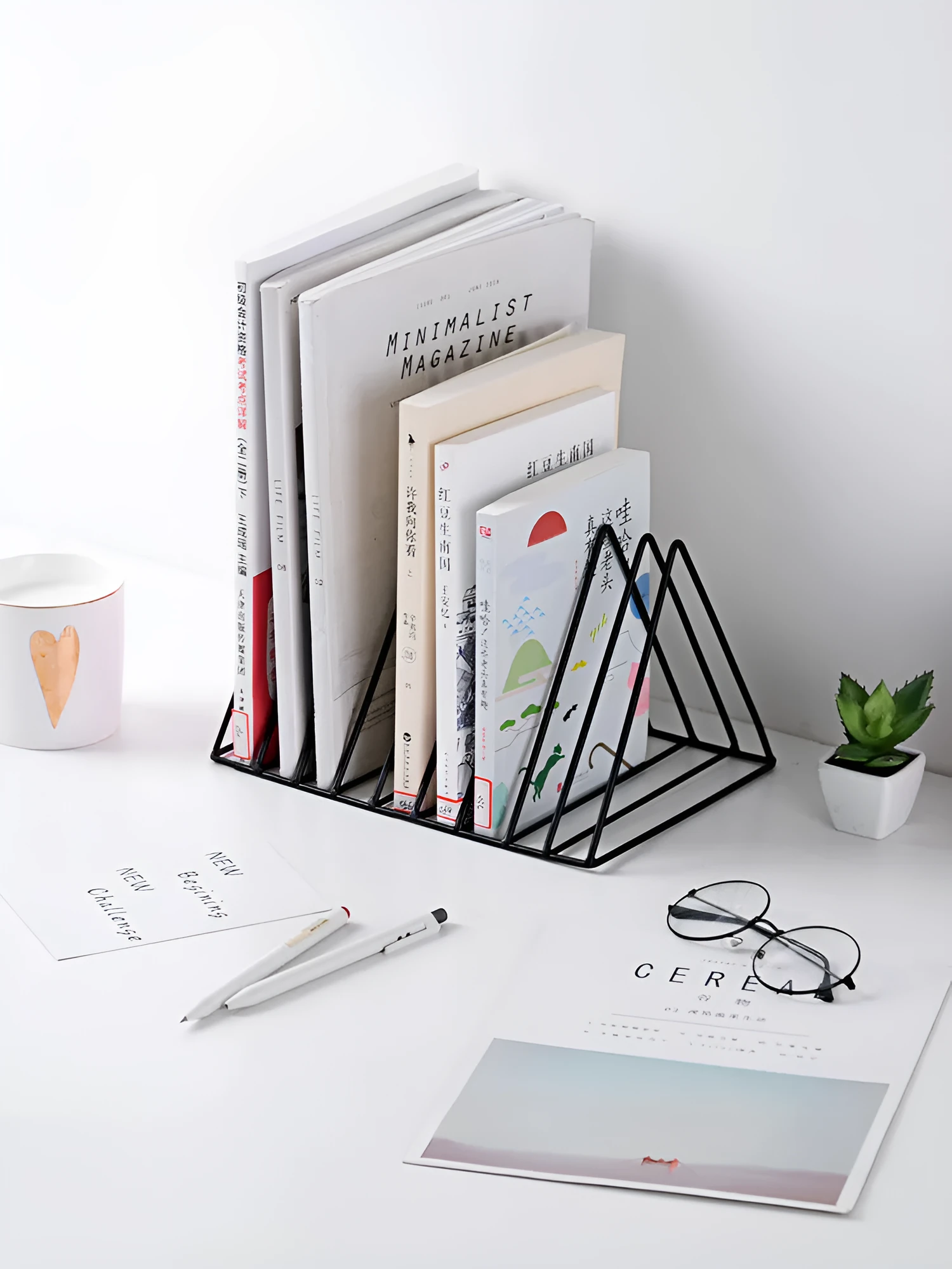 Wrought iron triangle book stand in black on a desk holding a book upright