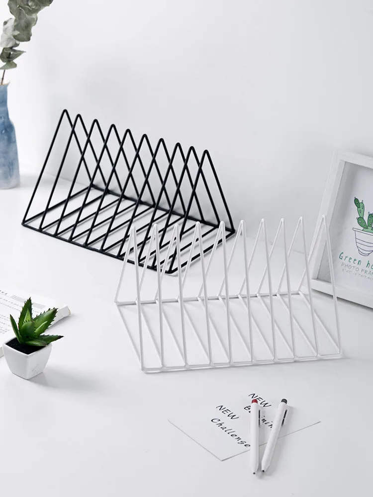 Wrought iron triangle book stand in black on a desk holding a book upright