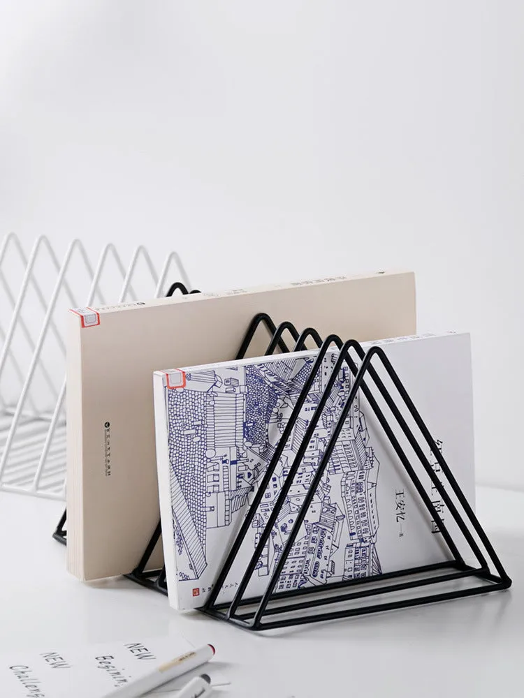 Wrought iron triangle book stand in black on a desk holding a book upright