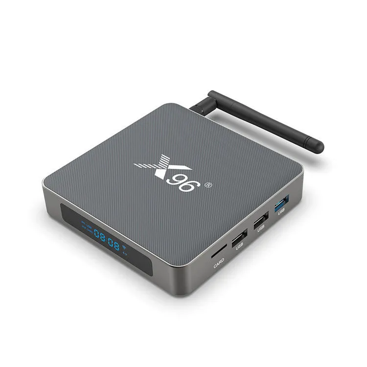 Android smart TV set-top box with voice remote control on a wooden table next to a television.