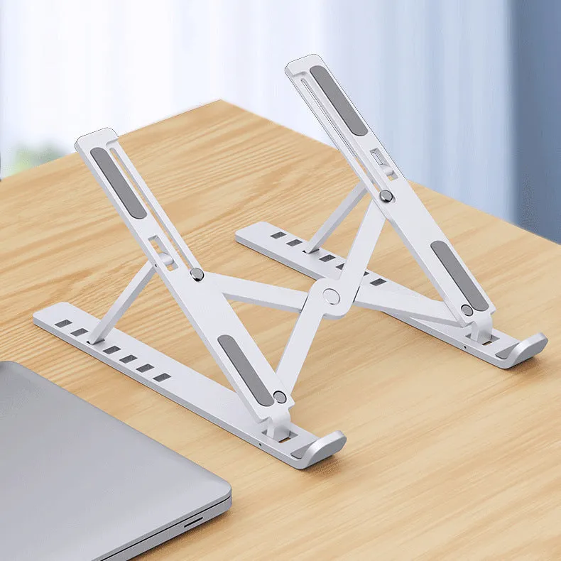 Folding aluminium alloy laptop stand in grey on a wooden desk, showing adjustable width and non-slip pads