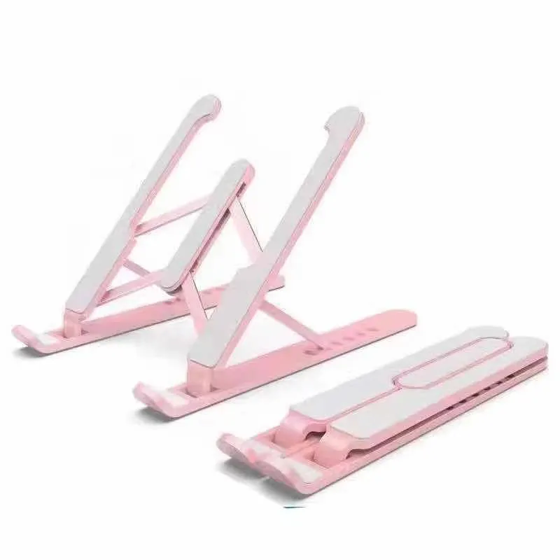 Folding aluminium alloy laptop stand in grey on a wooden desk, showing adjustable width and non-slip pads