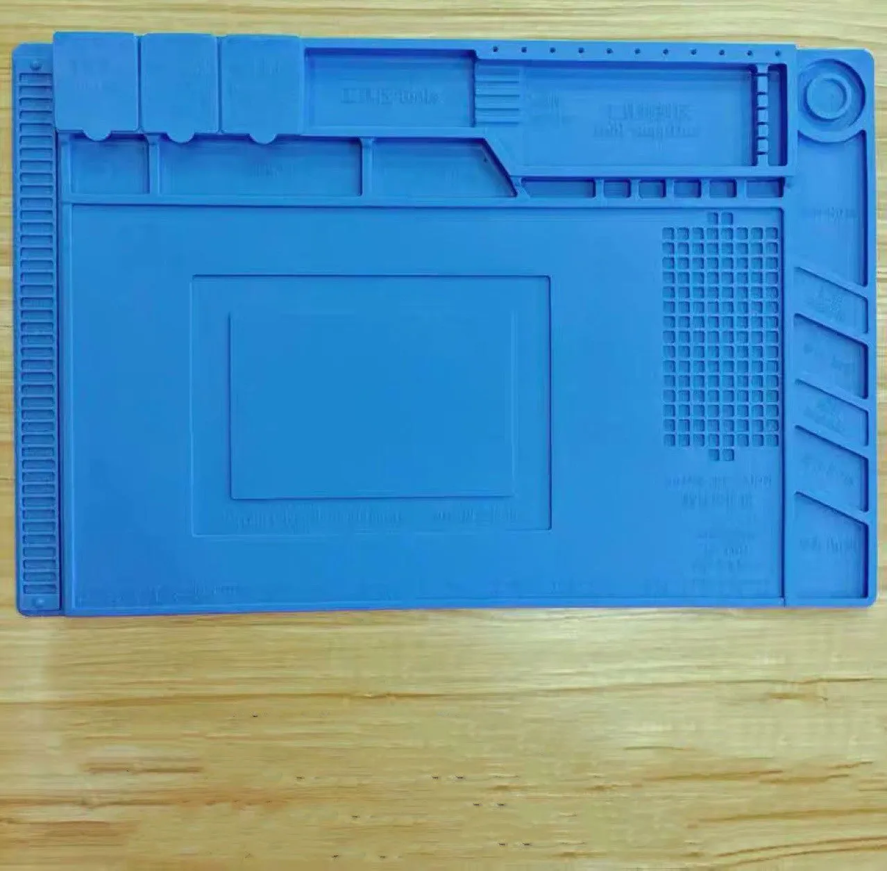 Blue mobile phone computer repair magnetic heat insulation work mat on a desk