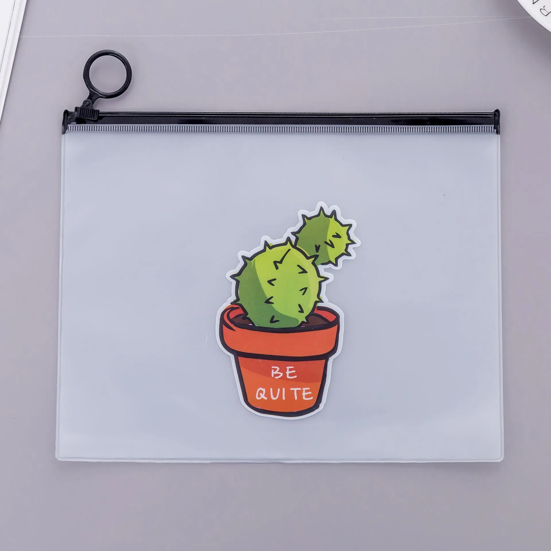 PVC pencil case with sealed closure, cactus print, 17.1x21.2cm, on a desk with stationery
