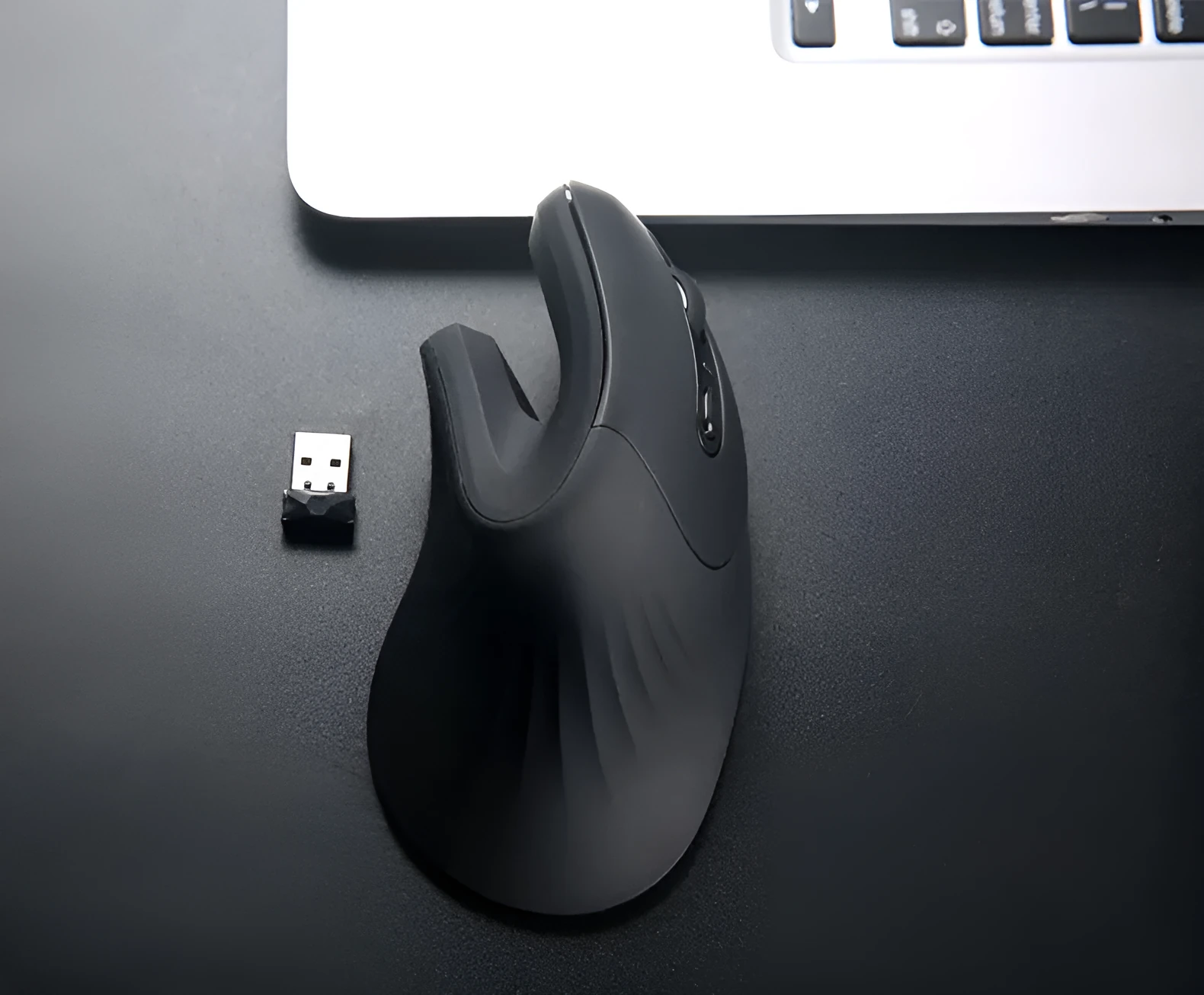 Wireless vertical mouse in black with ergonomic shape, six buttons, and diamond-pattern surface on a desk