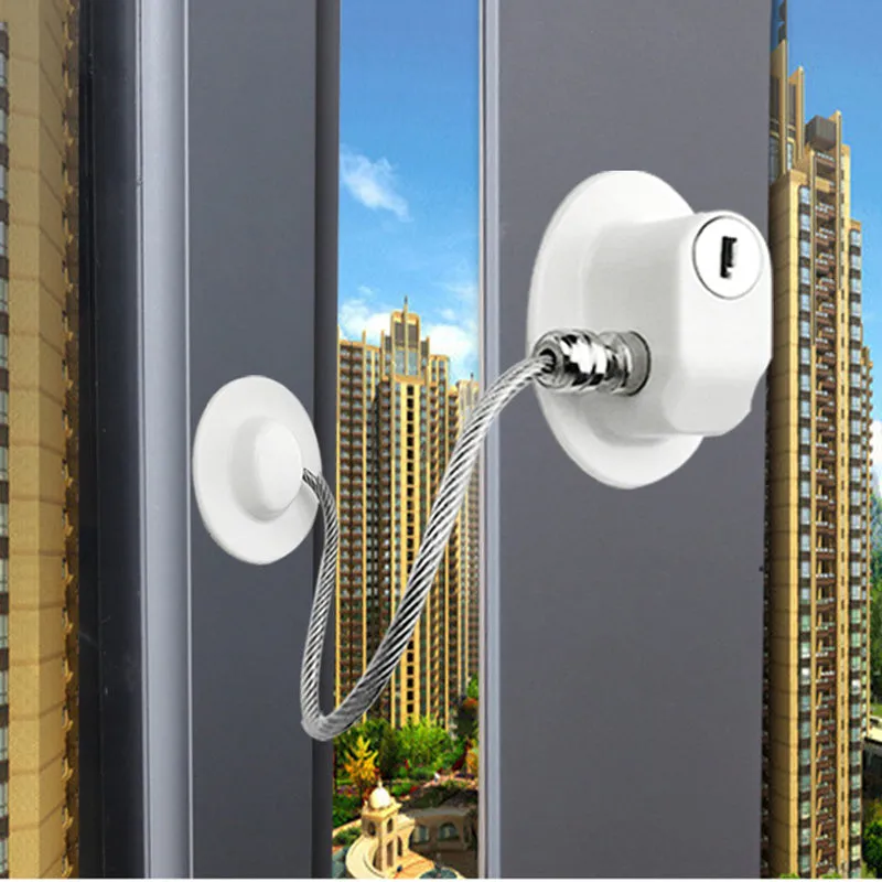 White window security chain lock with steel cable and adhesive base on a window frame
