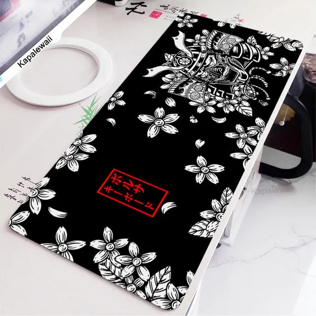 Large black and white gaming mouse pad with non-slip rubber bottom and cloth cover on a desk