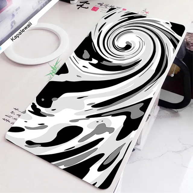 Large black and white gaming mouse pad with non-slip rubber bottom and cloth cover on a desk