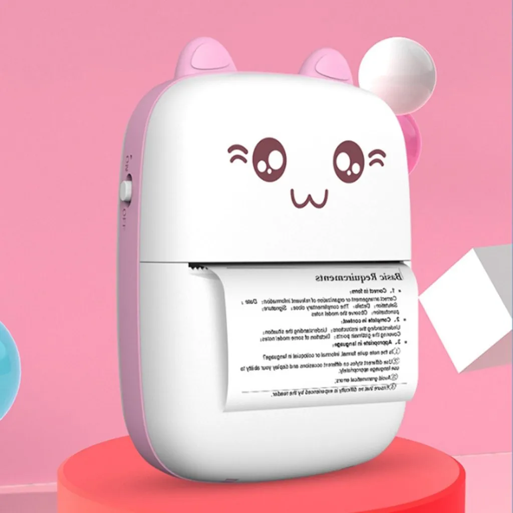 Pink mini Bluetooth thermal printer on a desk with a phone and printed note, measuring 11x8x3.5cm