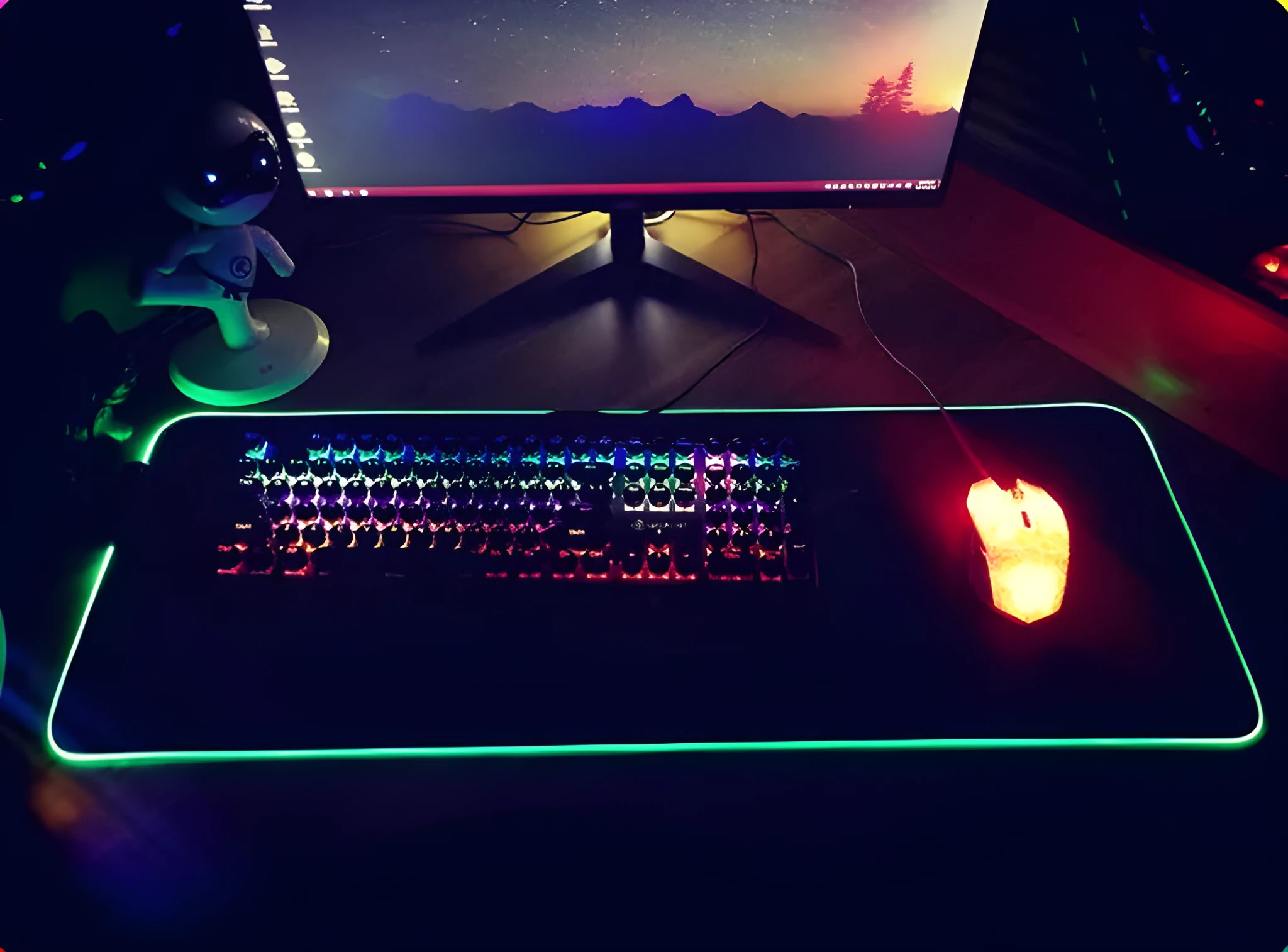 RGB luminous mouse pad with multi-colour LED lighting, fabric surface, and rubber base, shown on a desk with a mouse and keyboard