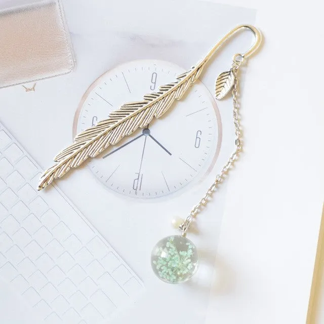 Creative metal bookmark with a dried flower inside, showing colour options like blue starry sky and dandelion.