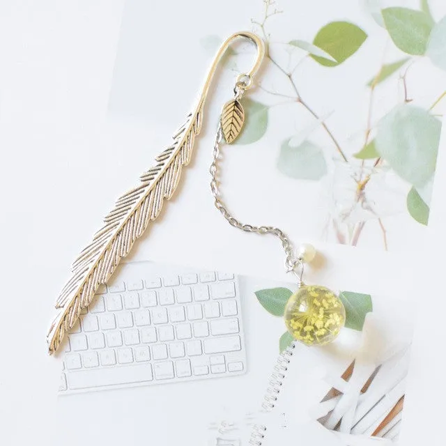 Creative metal bookmark with a dried flower inside, showing colour options like blue starry sky and dandelion.