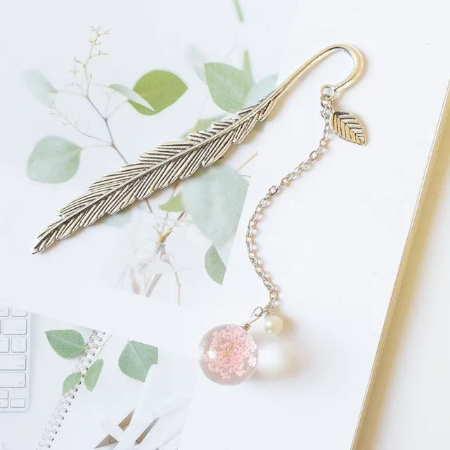 Creative metal bookmark with a dried flower inside, showing colour options like blue starry sky and dandelion.